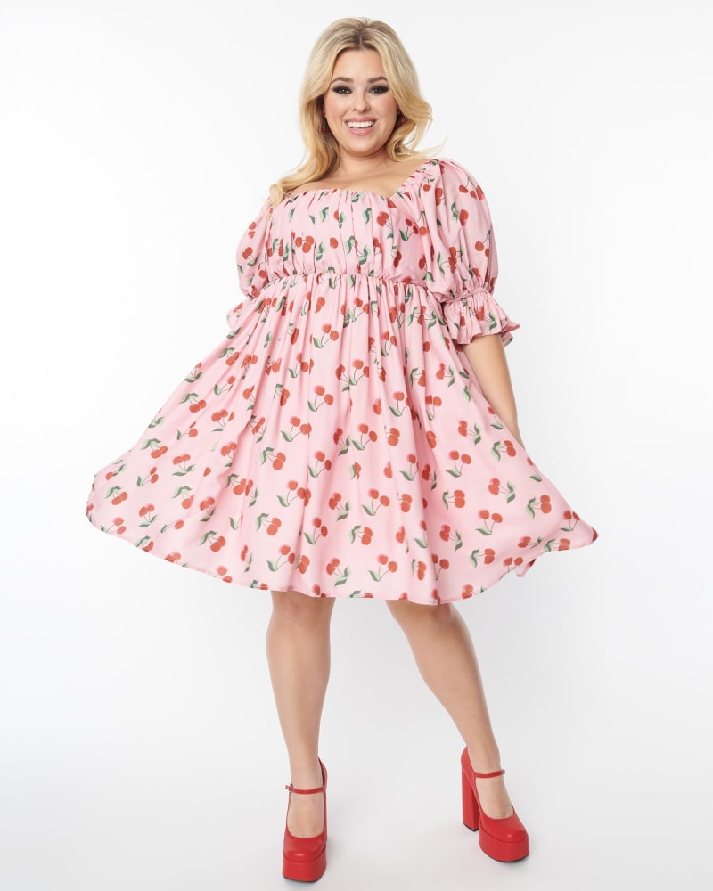 Front of a model wearing a size 3X/20 Smak Parlour Plus Size Pink & Cherries Love Interest Babydoll Dress in Pink & Cherries by Smak Parlour. | dia_product_style_image_id:269380